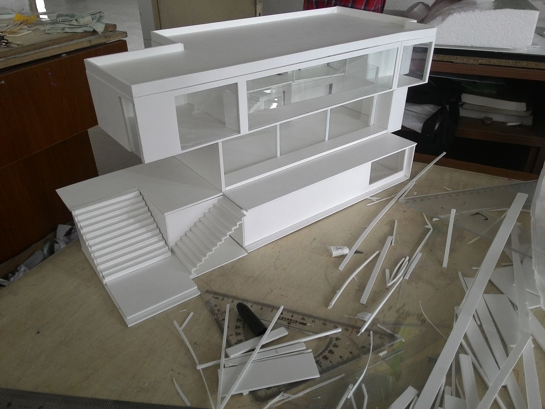 Oblique view of the white architectural model with its exterior stair and surrounding site