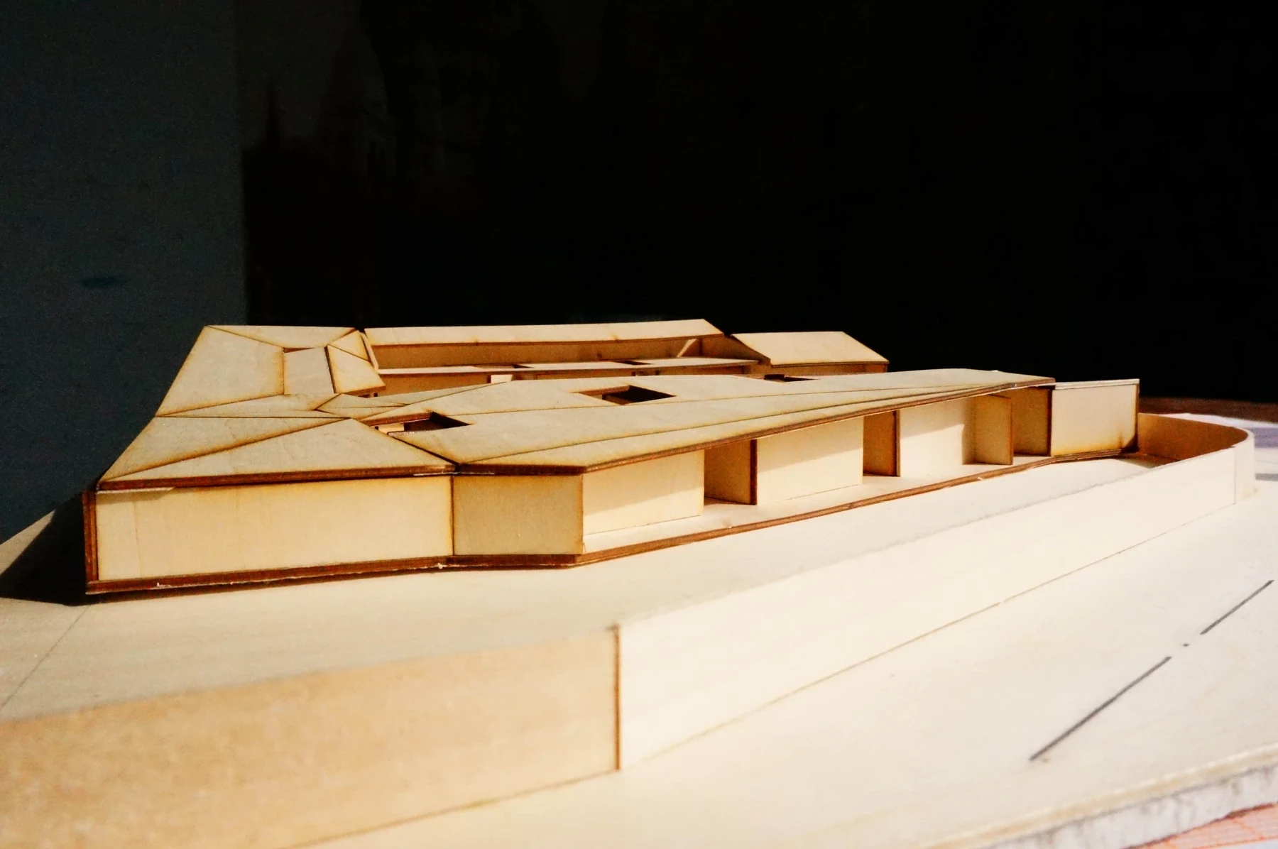 Eye-level photograph showing low walls, openings and sloped roofs of the model
