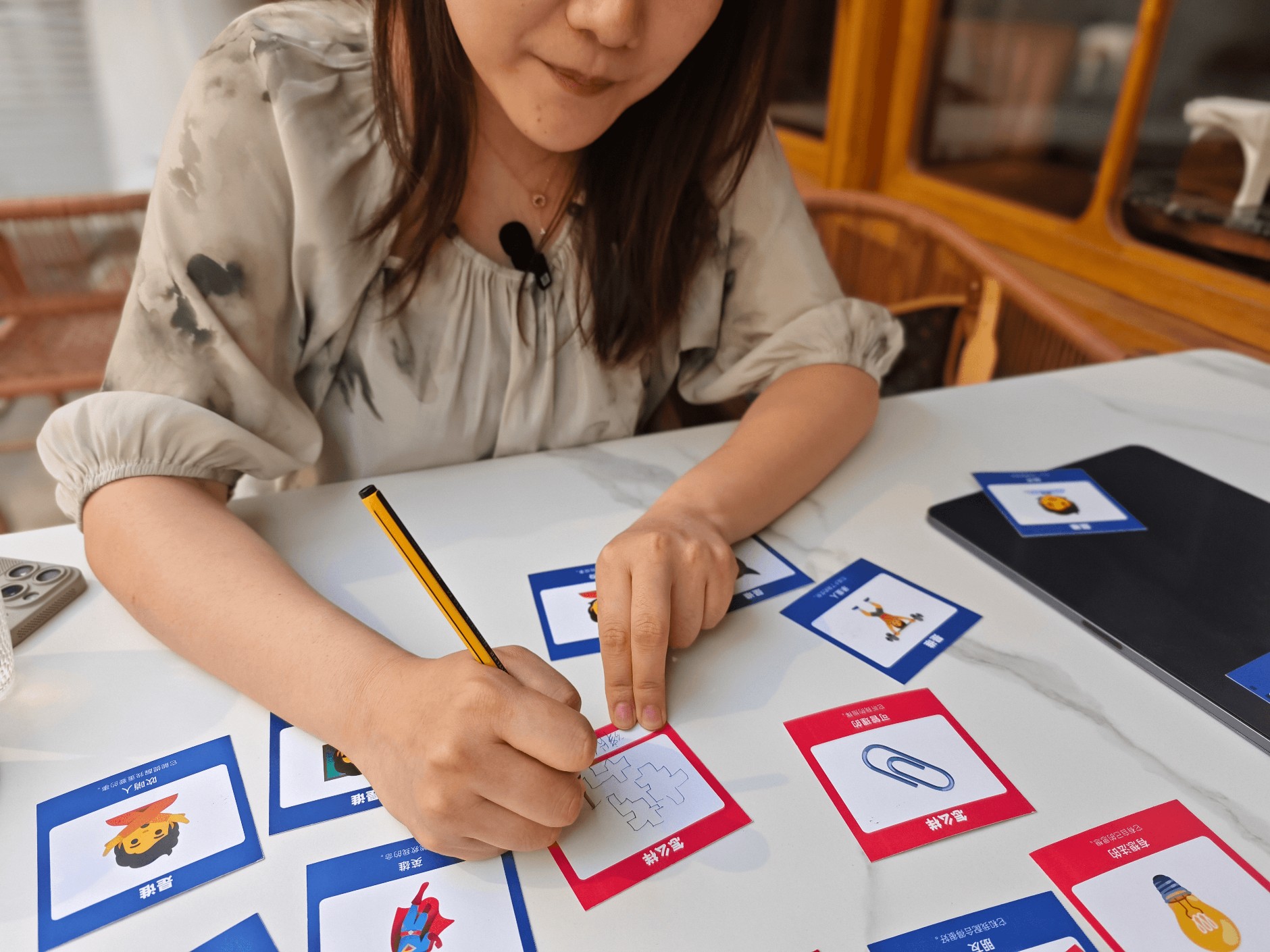 A participant drawing a custom How card during a research interview