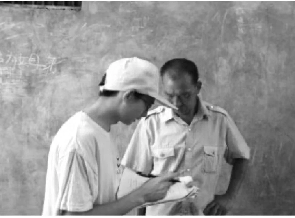 Two people examining documents during fieldwork, reproduced from the project materials